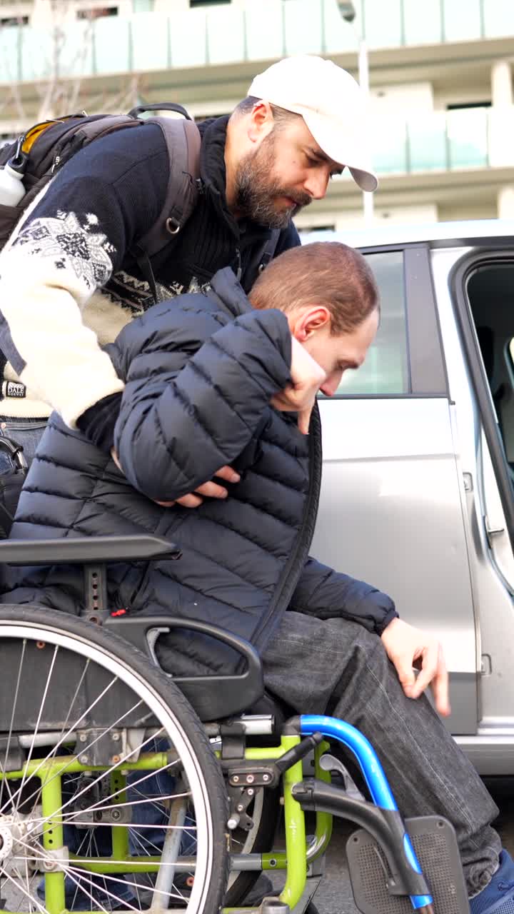 Assisting a man in a wheelchair to transfer into a car
