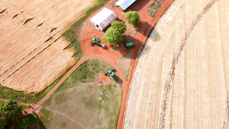 drone birds eye view of agricultural machines waiting to go harvest wheat