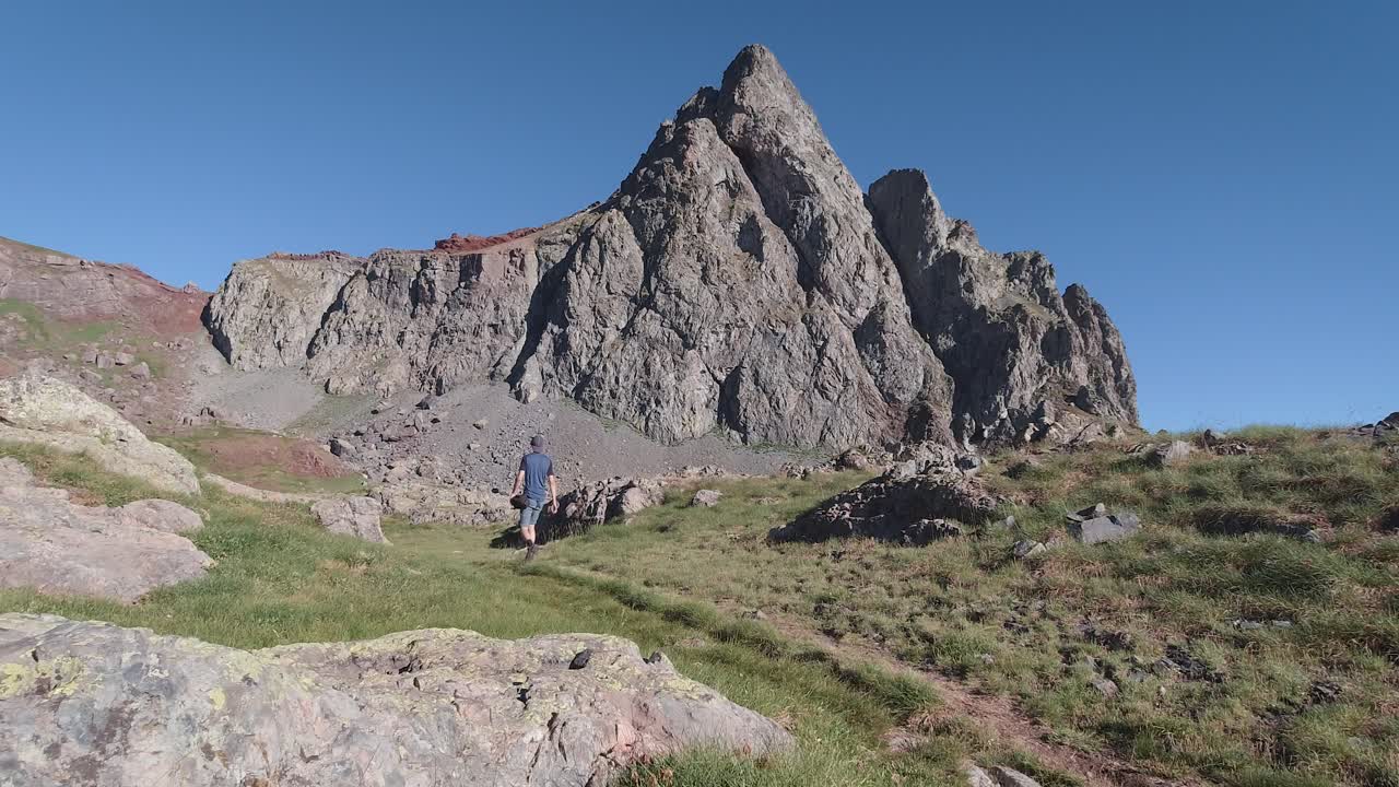 vista trasera del caminante caminando hacia el pico anayet durante la mañana de verano