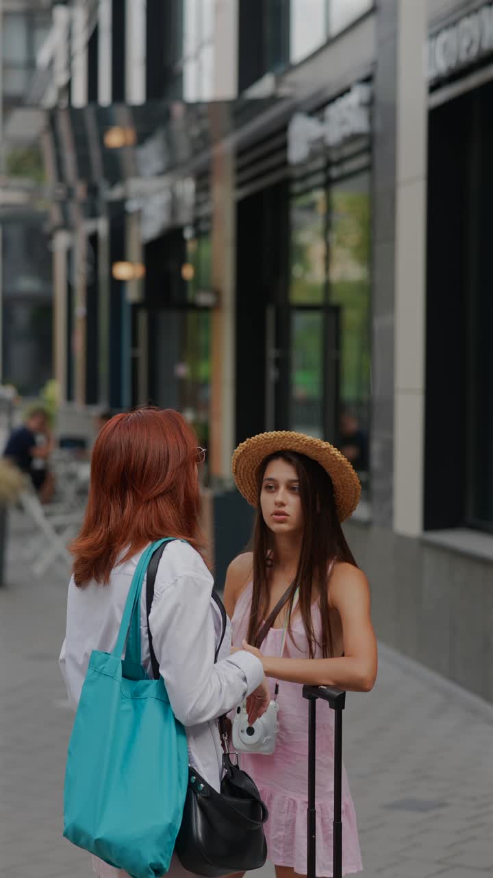 dos mujeres hablando en una calle de la ciudad