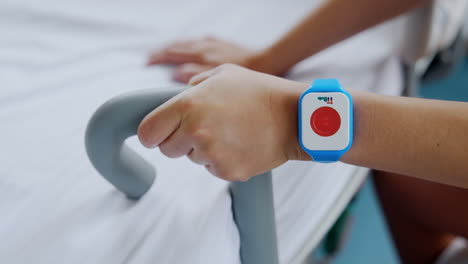 female hands holding for a handrail. pregnant lady is having emergency button for calling medical personnel. close up.