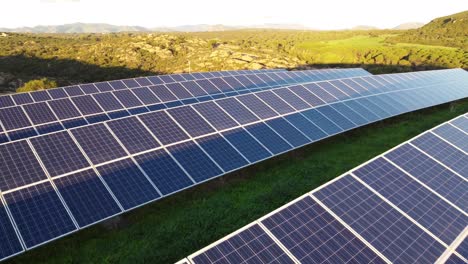 Close-up-of-Photovoltaic-Solar-Panel-station-farm-in-rocky-landscape,-sunset