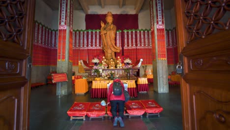 Man praying at sacred buddhist Jingan Temple precious hall facade