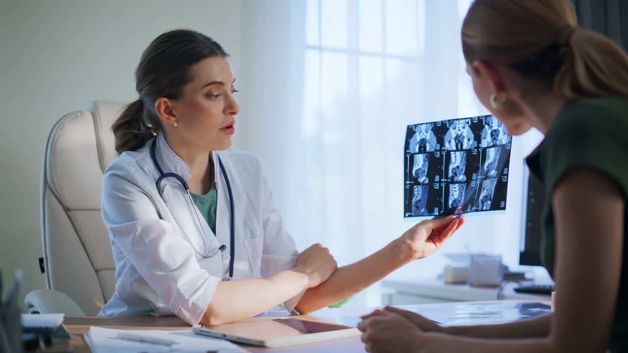 Doctor discussing scan diagnosis indoors closeup. Woman patient visiting clinic