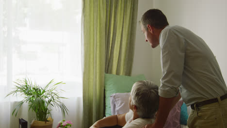 doctor helping senior woman in her room of retirement house