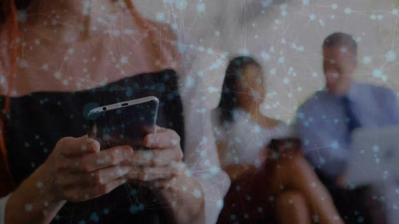 Donna leader che tocca il telefono, mostrando una sovrapposizione di rete mentre il team usa tablet e laptop per affari