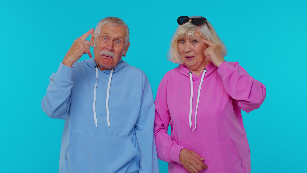 Senior Couple Pointing at Their Heads in Surprise