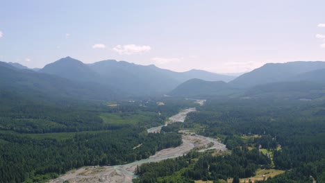 Asombrosa-Vista-Aérea-Del-Río-Cowlitz-Rodeado-De-Frondosos-árboles-En-El-Estado-De-Washington-Con-Un-Valle-Brumoso-En-El-Fondo---Disparo-De-Drone-Ascendente