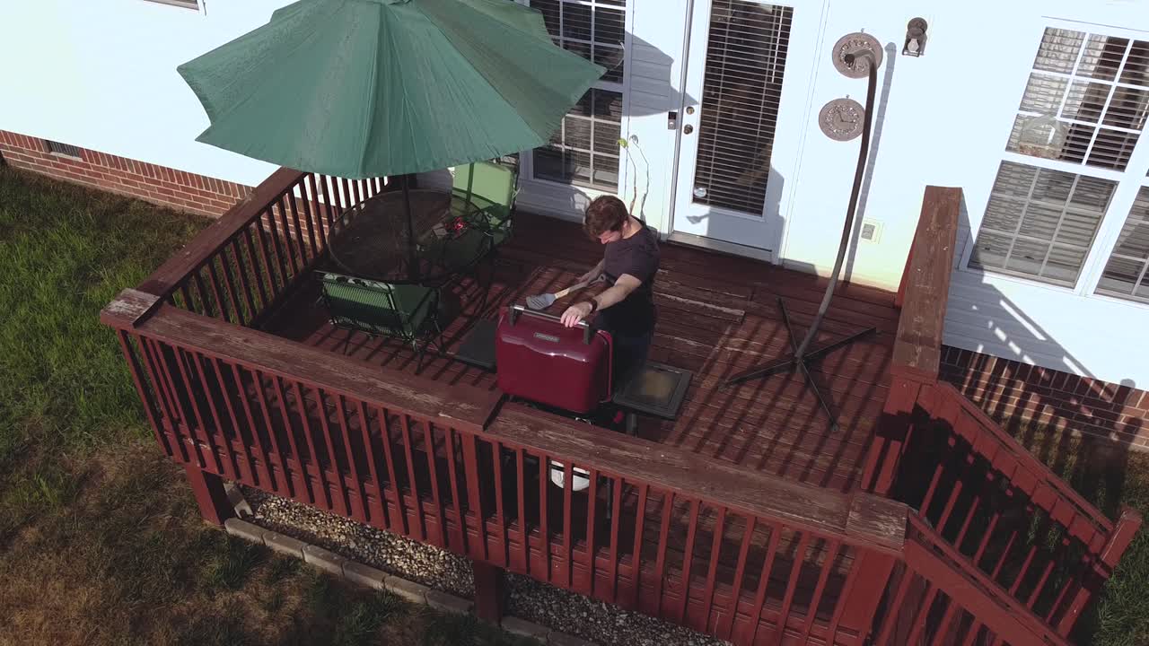 Man Grilling on a Red Deck, High Angle