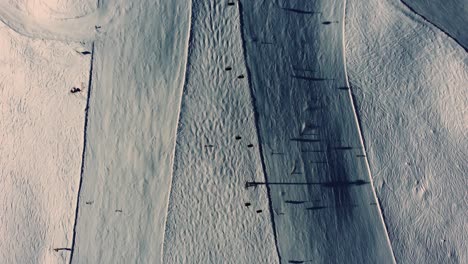 Top-down-of-ski-slope-with-skiers-and-mountain-chair-lift-in-Alps