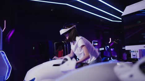 woman using vr motorcycle simulator in an arcade