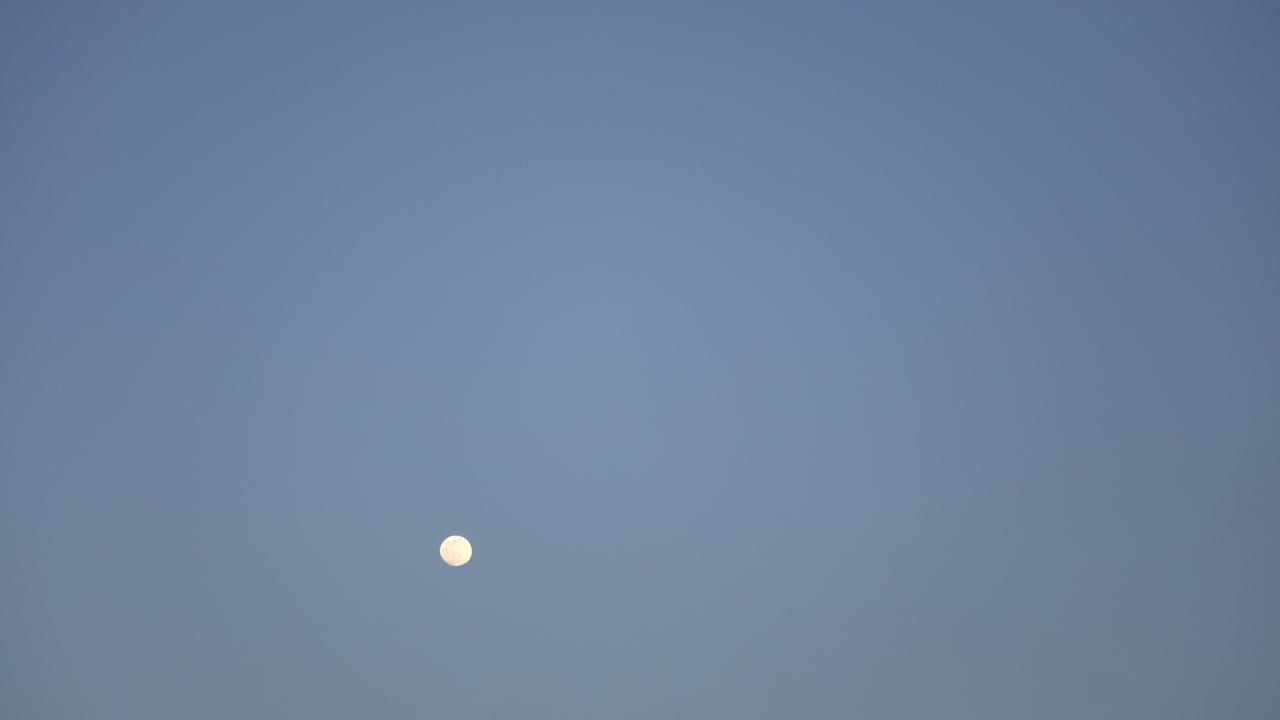 어두운 밤 하늘을 가로질러 움직이는 밝은 보름달의 시간 간격 클로즈업.