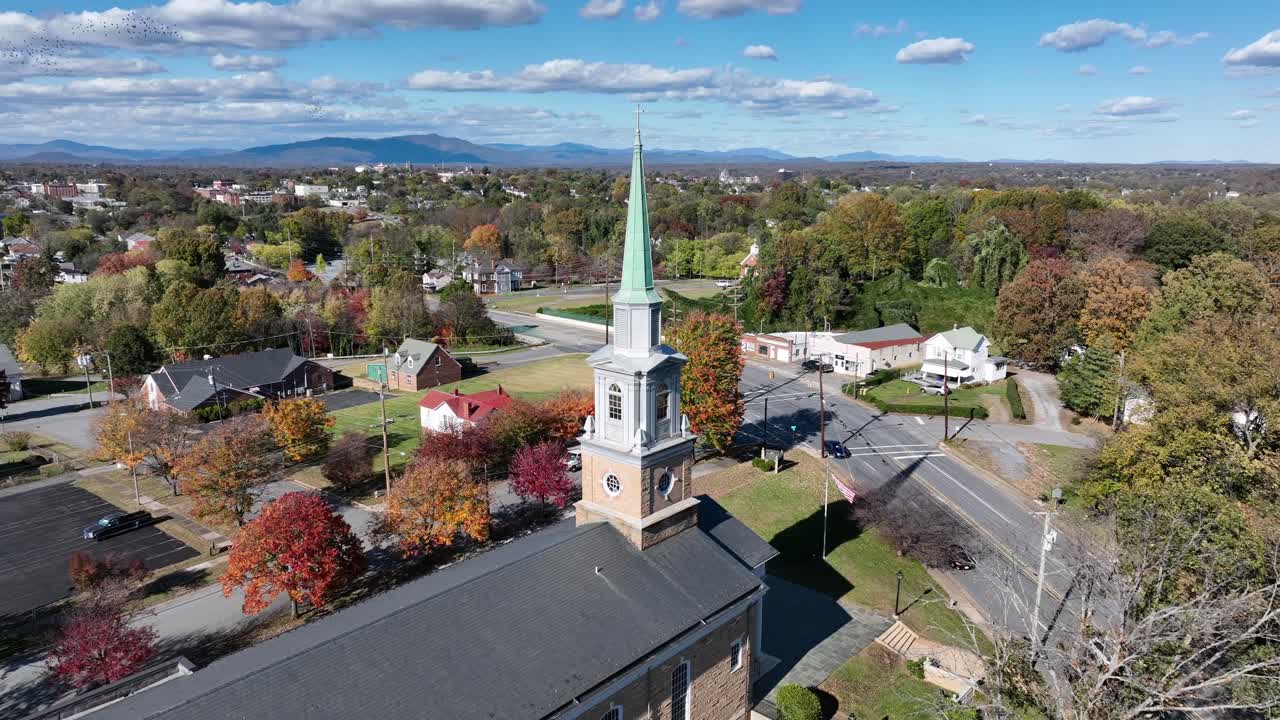 Aerial approacjing shot f church tower with driving cars on Main Street. Sunny day in small sitoric town of uSA. Lynchburg,Virginia in Autumn season. Wide shot