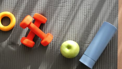 fitness equipment and healthy snack on a mat