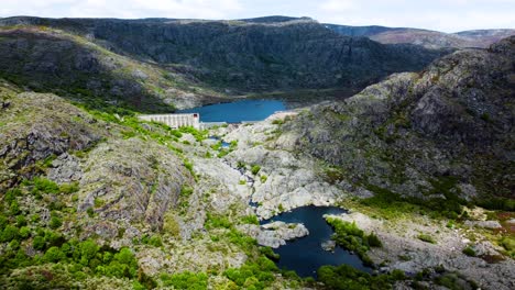drone pullback from dam and river of rio tera canyon, cloud shadows over water and mountain