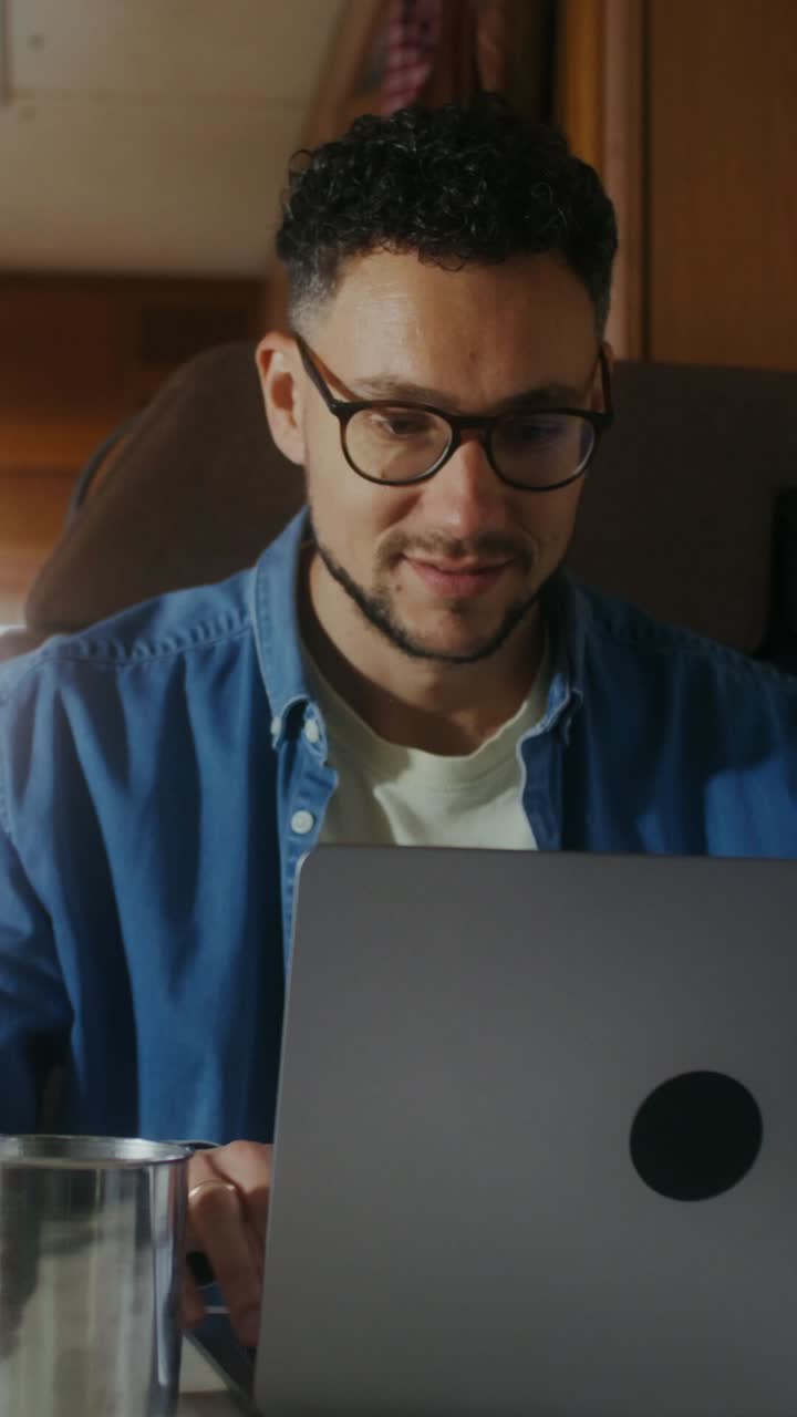 hombre trabajando en una computadora portátil y bebiendo café
