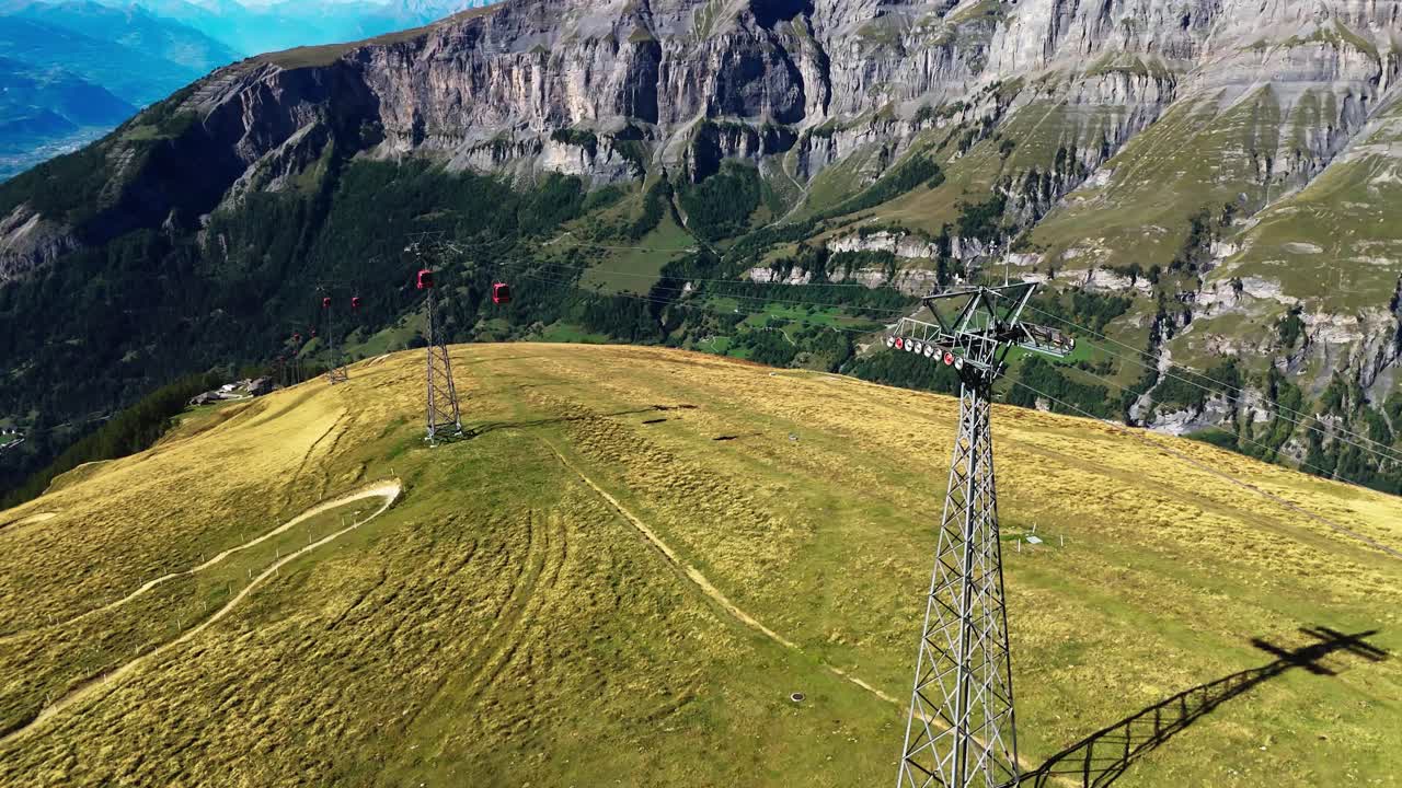Drone footage showing a cable car system and mountain landscape near Leukerbad, Switzerland. Scenic aerial view of alpine nature, tourism, and travel destination