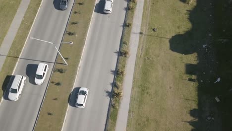 aerial drone shot looking vertically down highway with cars going through