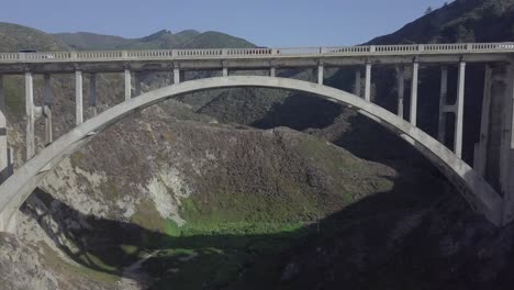 aerial drone shot of bixby bridge with road and vehicles