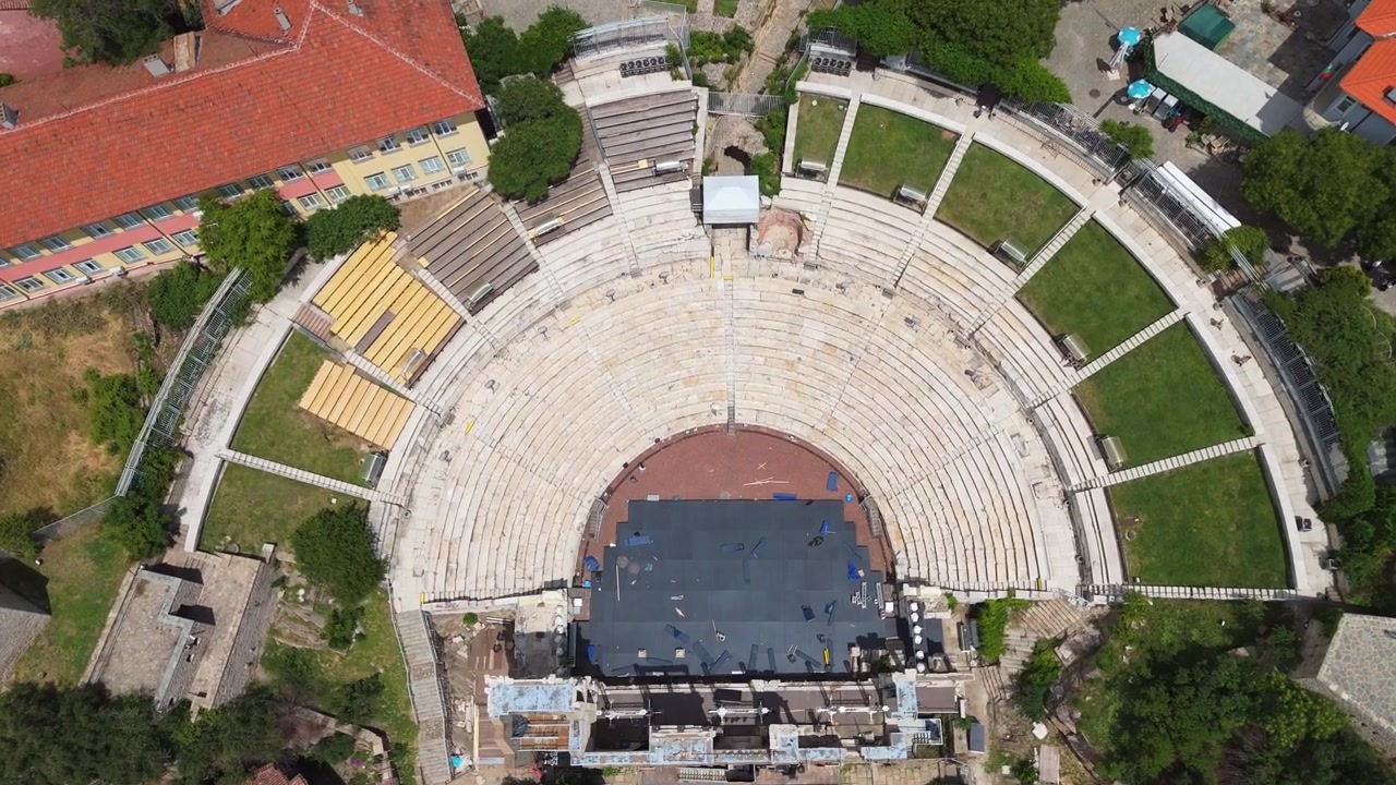 Bulgaristan'ın Filibe (Plovdiv) şehrindeki antik Roma tiyatrosu kalıntılarının kuşbakışı drone görünümü. Tarihi şehir parkı yamacına entegre edilmiş yarı dairesel taş oturma yapısı