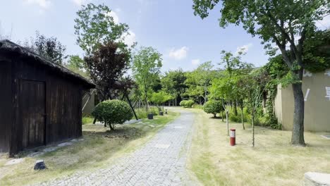 old earth houses sit empty in a serene park in china, encircled by greenery
