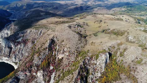 Vista-De-Pájaro-De-Tierras-Desiguales-Y-áridas-Sobre-Montañas-De-La-Meseta-De-Pester-Con-Sombras-De-Nubes-Sobre-Ellas