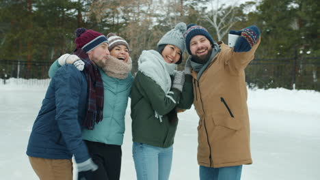 friends taking a selfie on an ice skating rink in winter