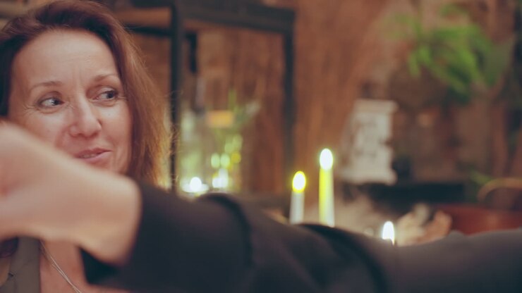Florist shop candlelit mentorship and chat, experienced florist listens and advises by candlelight among plants and rustic decor, closeup expressions and gentle gestures convey trust and quiet