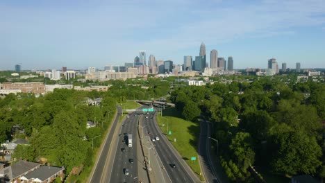 Drone-Vuela-Sobre-La-Carretera-Con-El-Horizonte-De-Charlotte-En-Segundo-Plano