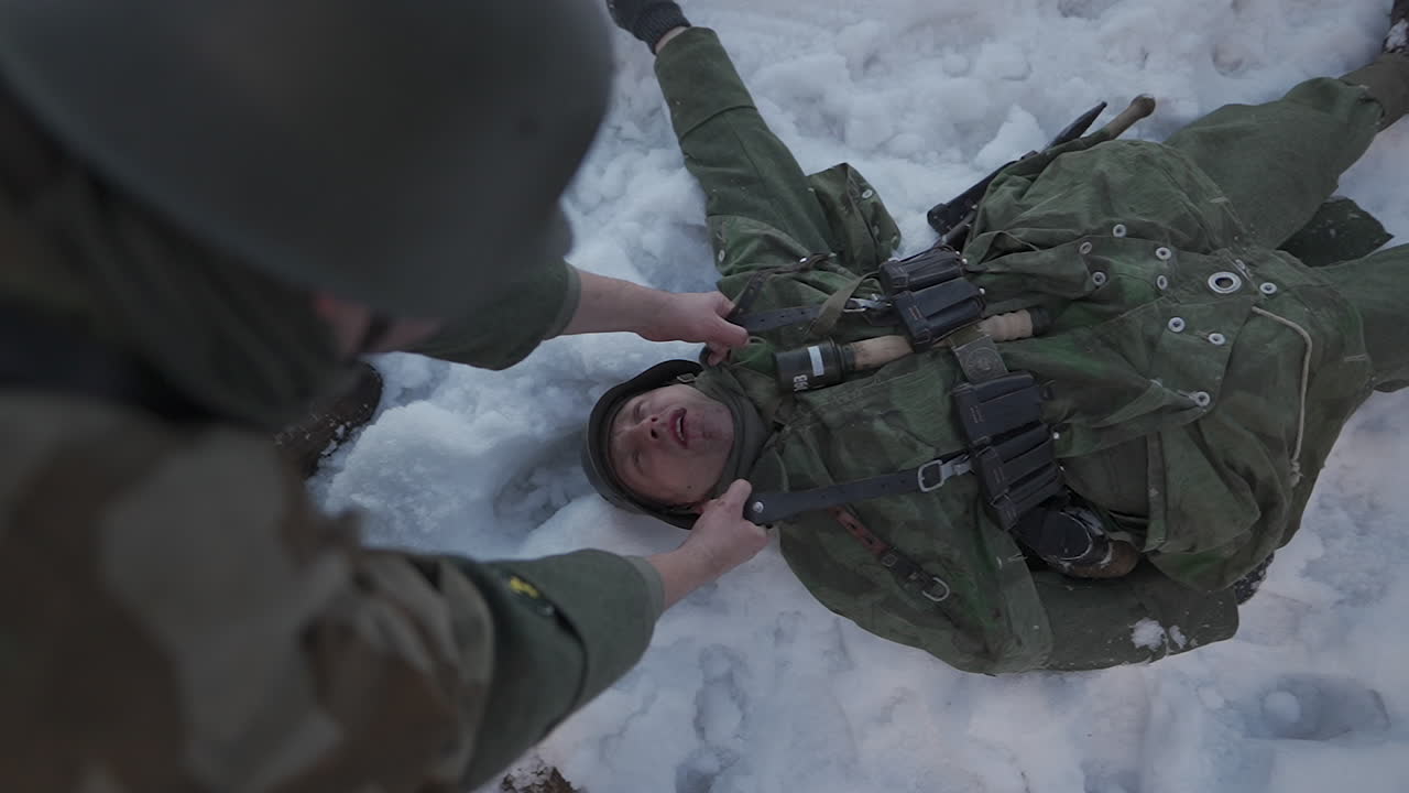 Injured Soldier Receiving Aid in Snowy Terrain