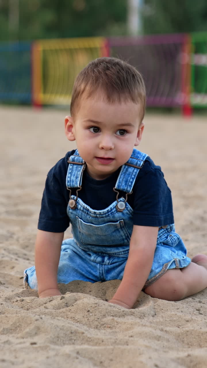 Sommerlicher Kinder-Lifestyle. Kleiner Junge hat Spaß auf dem Spielplatz. Vertikales Video