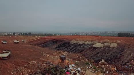 power shovel moves piles of garbage for later compaction at the brasilia landfill