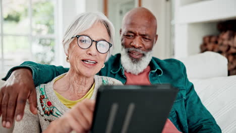 una pareja vieja en el sofá con una tableta.