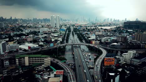 aerial scenic drone footage of a highway in downtown bangkok, thailand on a rainy day