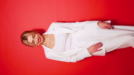 woman in white suit against red background