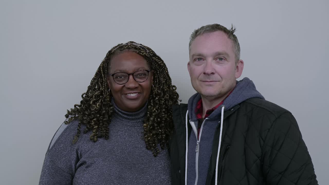 Portrait of beautiful mixed race couple, holding each other, smiling, looking at camera