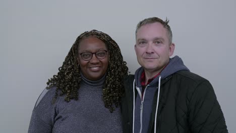 portrait of beautiful mixed race couple, holding each other, smiling, looking at camera