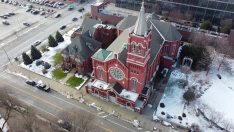 Birds-Flying-Over-Snowy-Catholic-Church-in-Rochester,-New-York