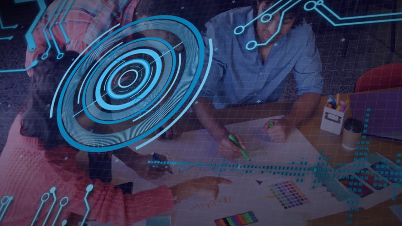 Equipo colaborando sobre muestras de diseño gráfico en un espacio de trabajo, mostrando una superposición de cuadrícula azul animada.