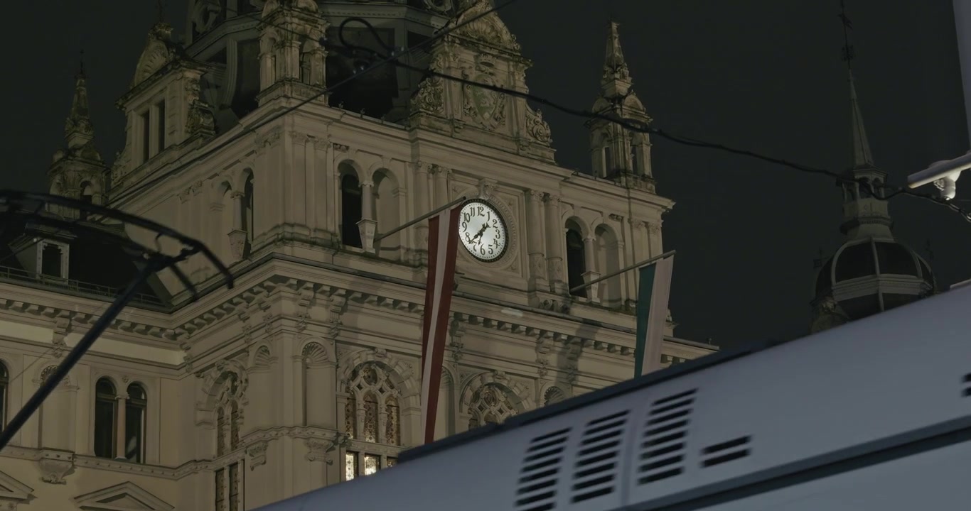 Illuminated clock tower of Hauptplatz Graz during nighttime
