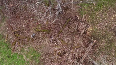 Scattered-wooden-planks,-remains-of-old-wooden-house-in-top-down-aerial