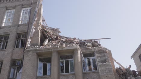 panning shot of missile strike aftermath on school building with collapsed second story