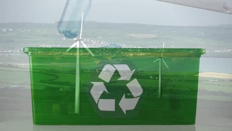 Animation-of-green-recycling-sign-over-box-with-plastic-bottles-and-wind-turbines