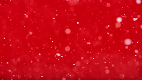 soft snowfall filmed in slow motion against glowing red background creates calm