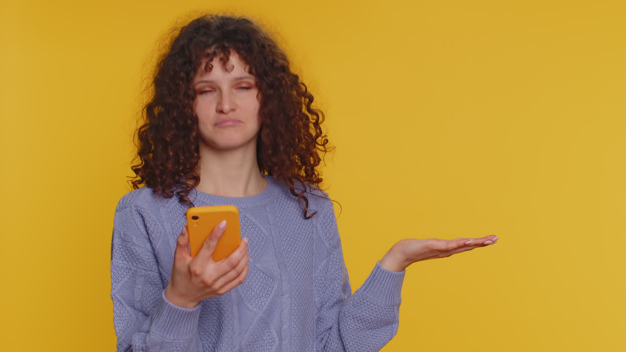 mujer sonriente sosteniendo un teléfono mirando a la cámara