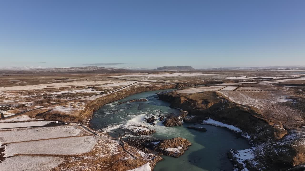 Aerial - Urriðafoss waterfall cutting through winter plains in south Iceland