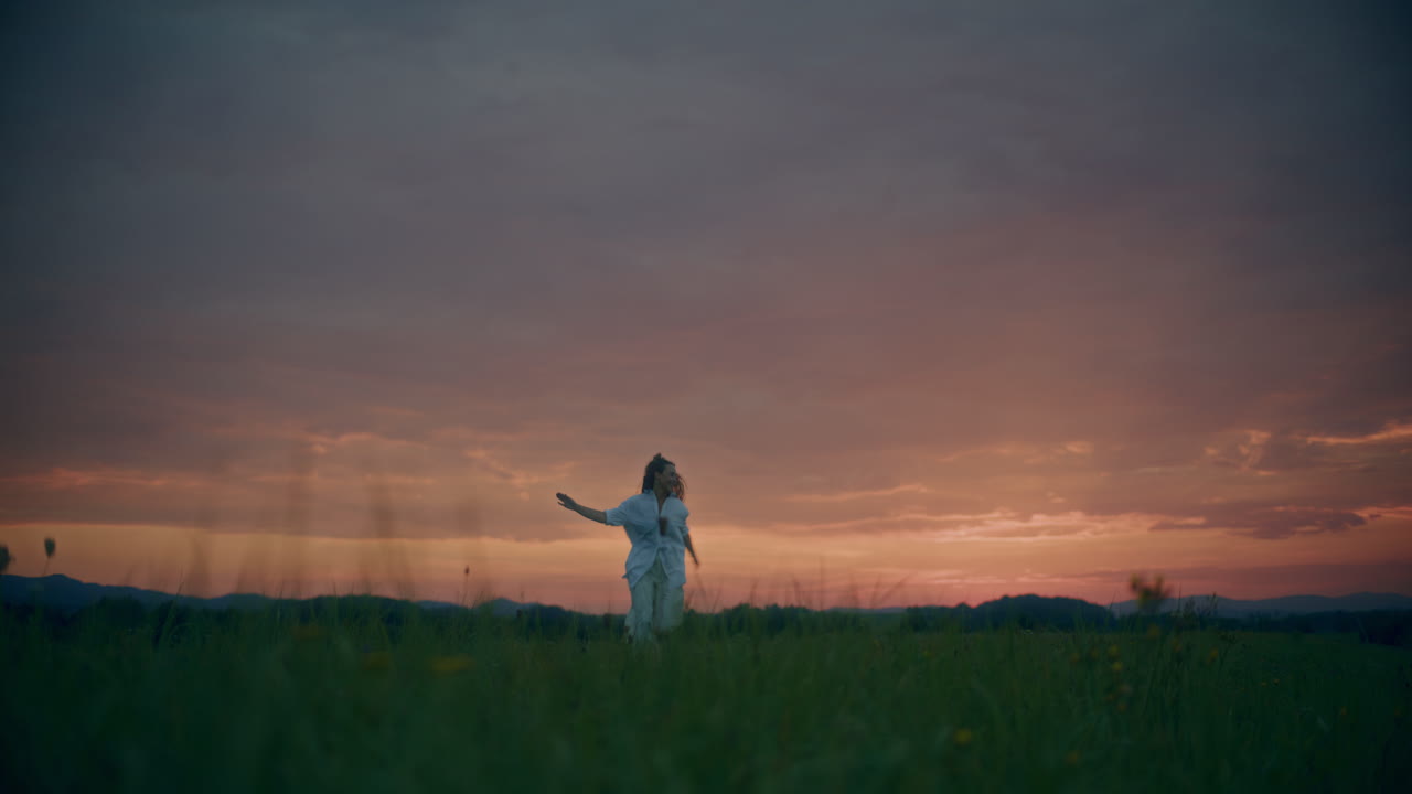 어두워지는 초원에서 달리는 여자