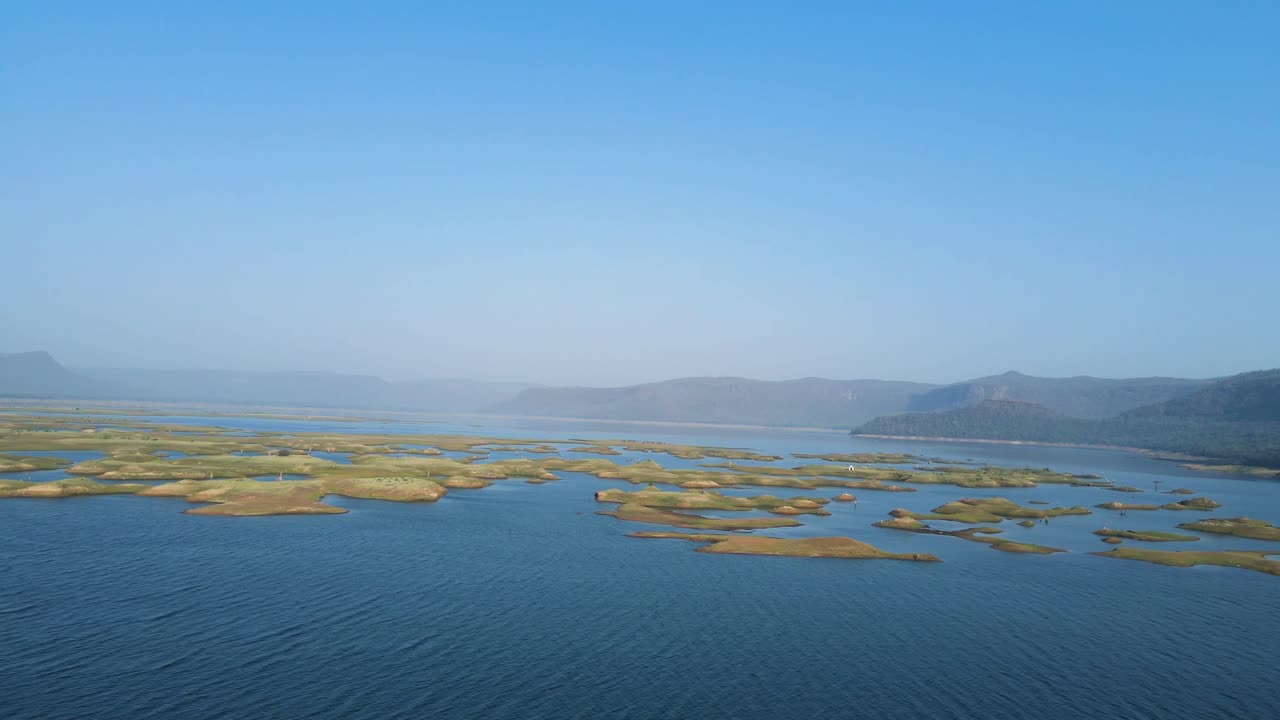 Stunning aerial view of Karamchat Dam, with the calm waters reflecting the surrounding greenery.