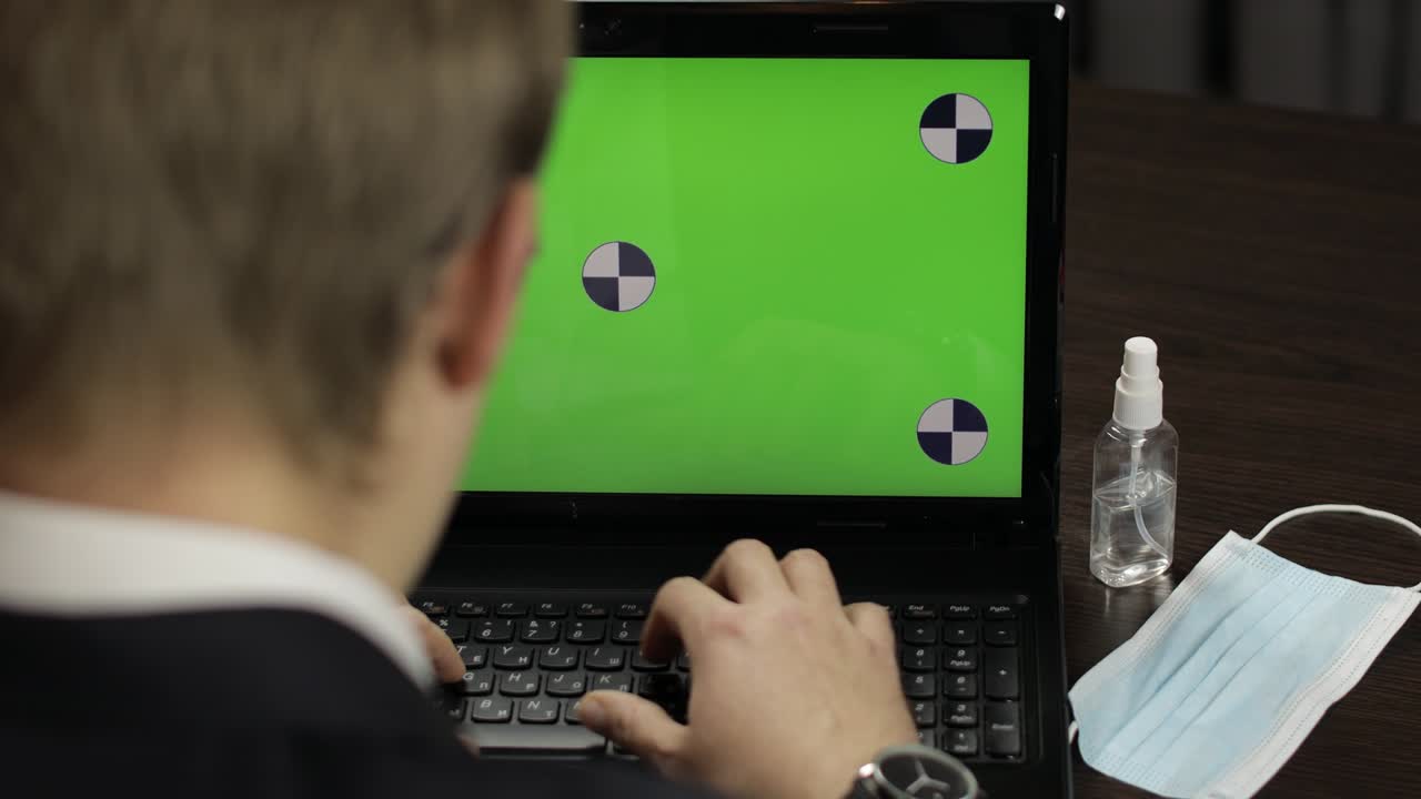 hombre está escribiendo en el teclado de la computadora portátil con pantalla verde, tecla de croma. trabajo a distancia