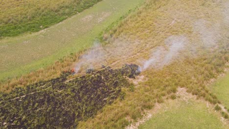 Aerial-view-over-dense-smoking-burning-crop-stubble-on-remote-Indian-agricultural-paddy-field-farmland